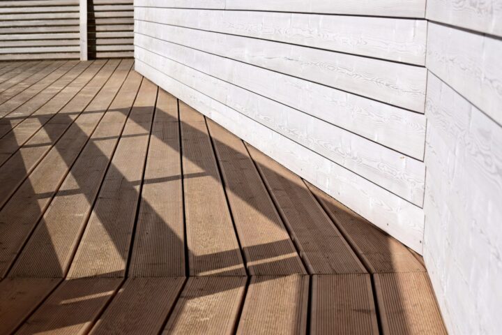 the shadow of a person standing on a wooden deck