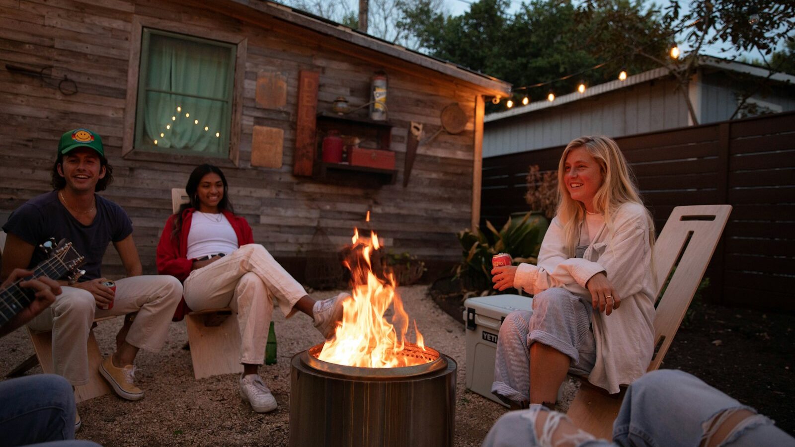 a group of people sitting around a fire pit