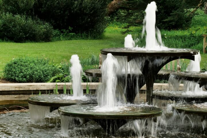 A tiered fountain sprays water in a garden