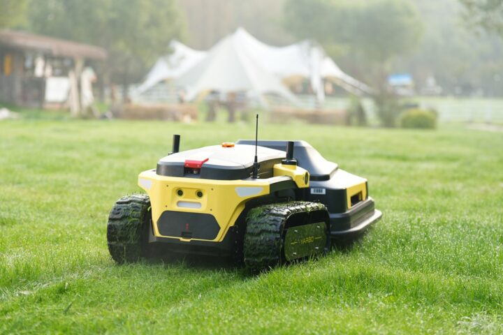 Robot lawnmower cuts grass in a backyard.