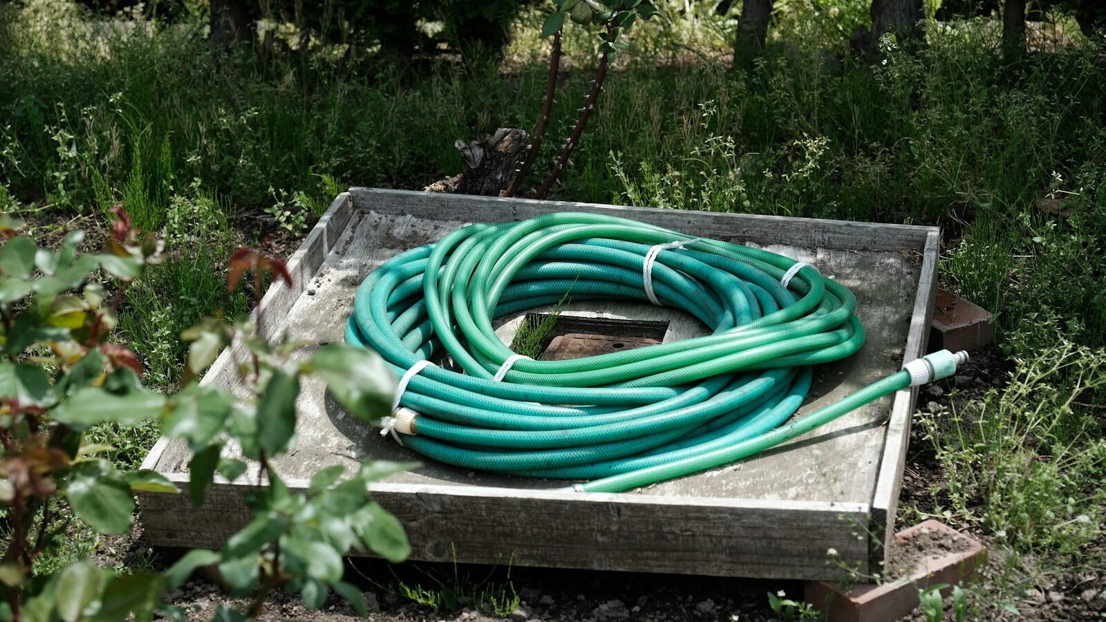 a bunch of green hoses sitting on top of a wooden box