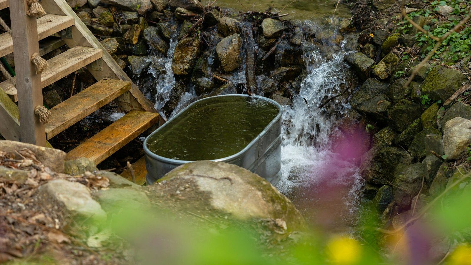 a bucket full of water next to a waterfall