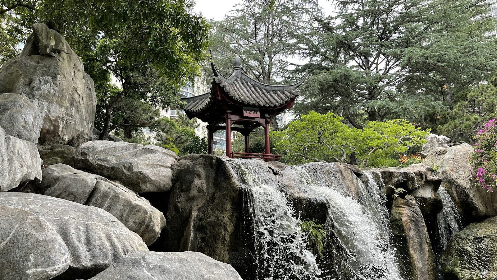 a waterfall with a pagoda in the middle of it