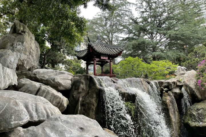 a waterfall with a pagoda in the middle of it