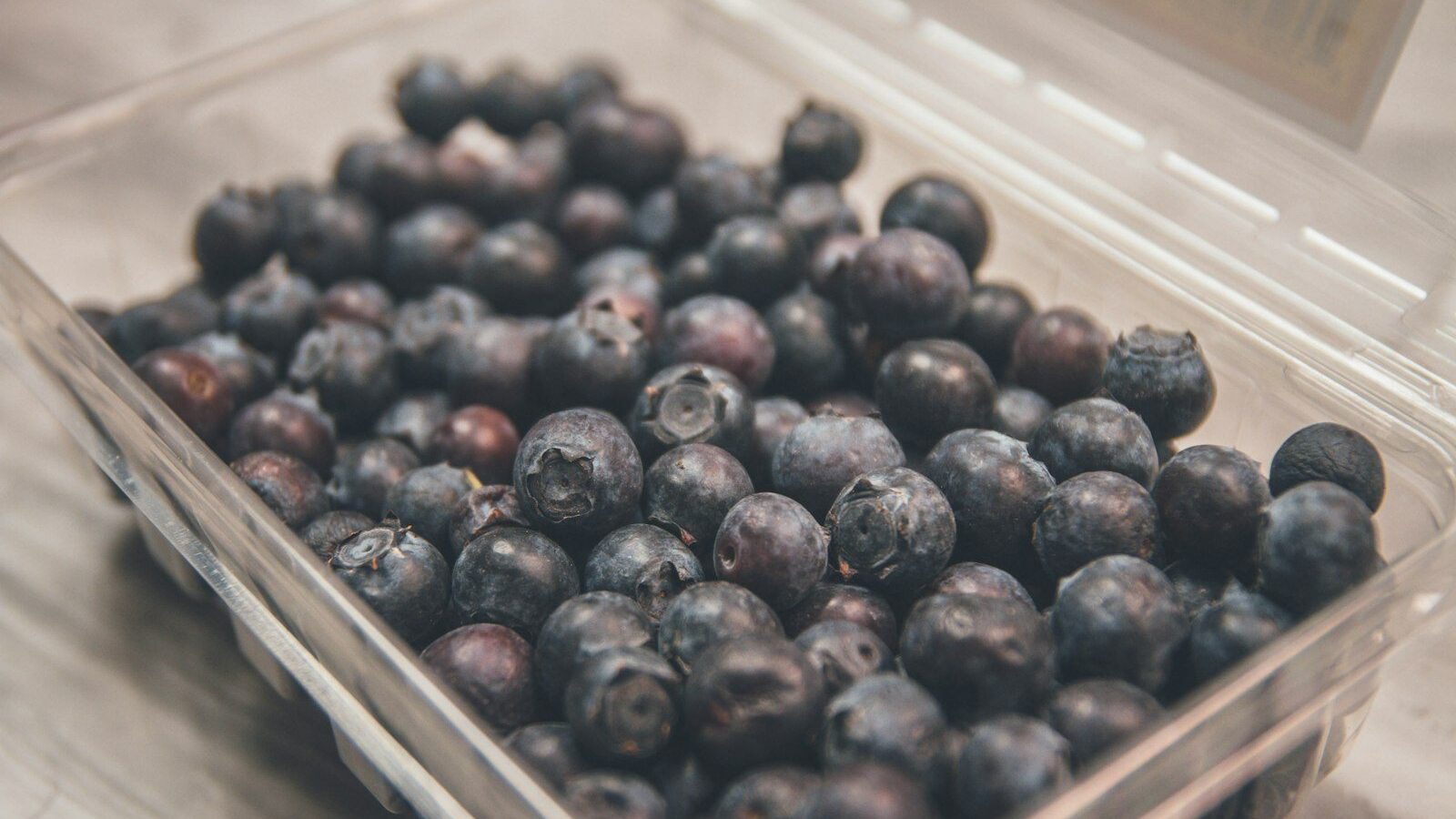 shallow focus photo of blueberries on clear plastic case