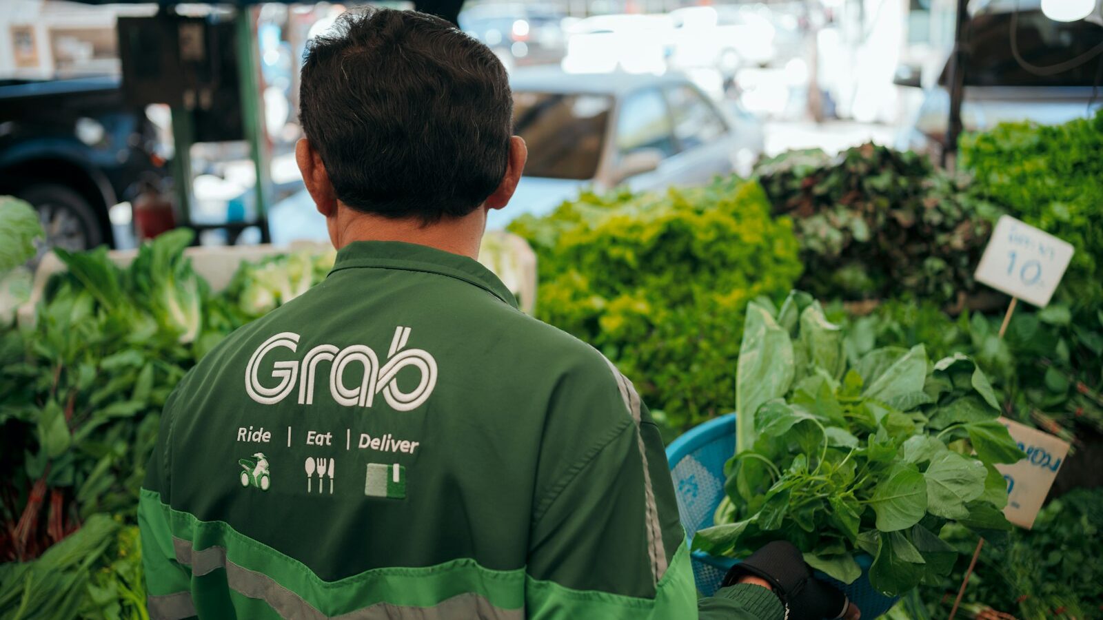 a man standing in front of a bunch of vegetables