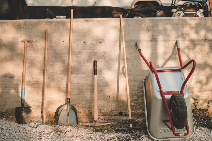 red and black shovel beside brown wooden stick