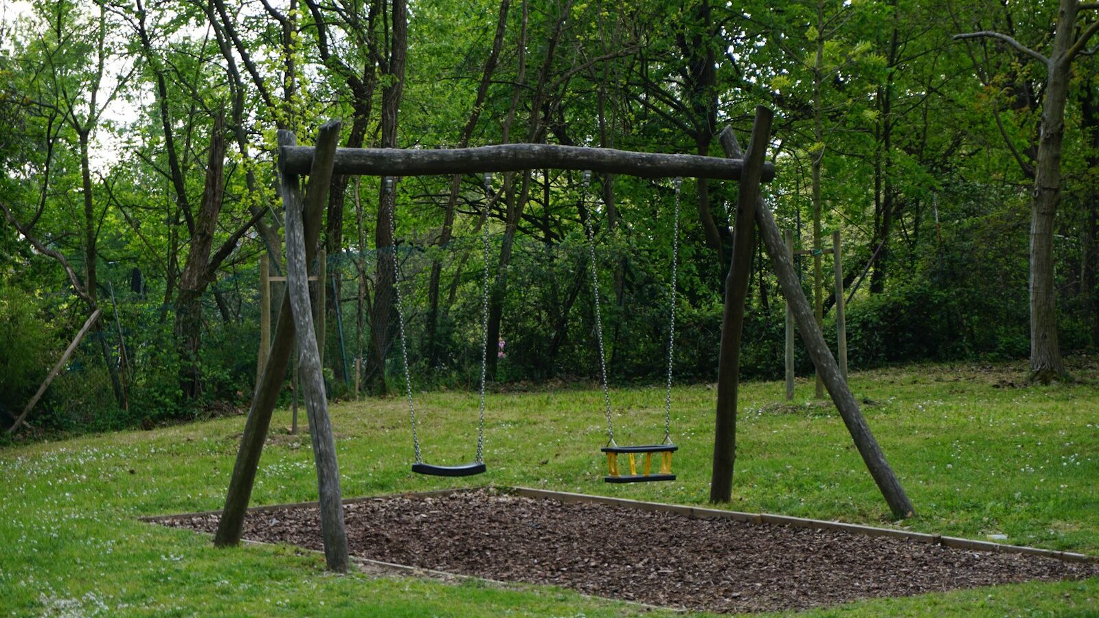 brown wooden swing on green grass field