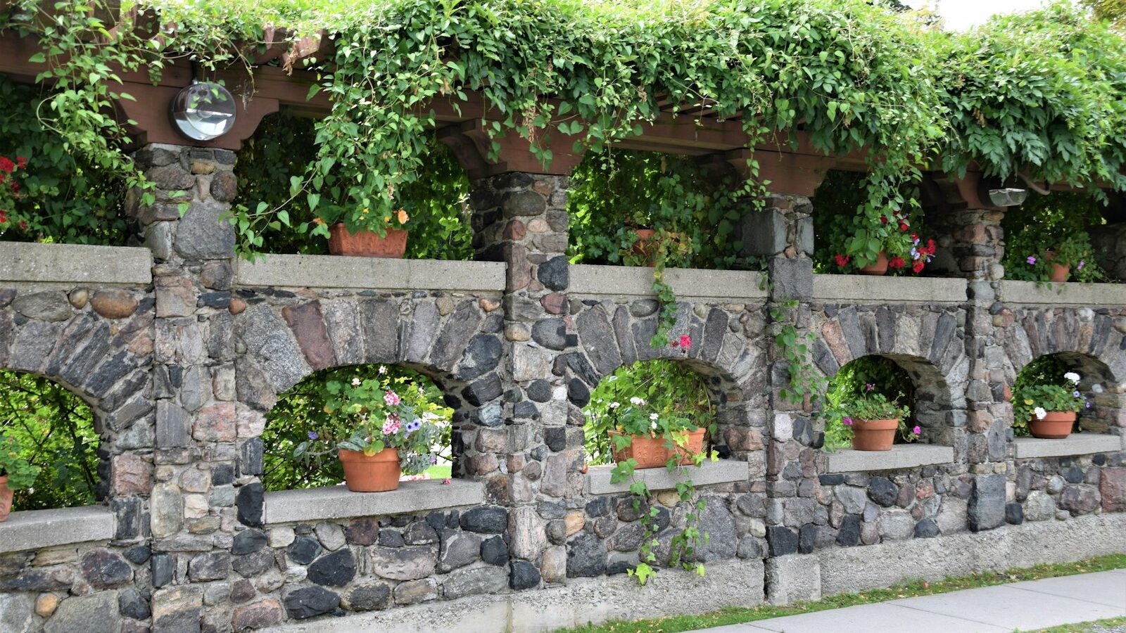 a stone wall with potted plants on it