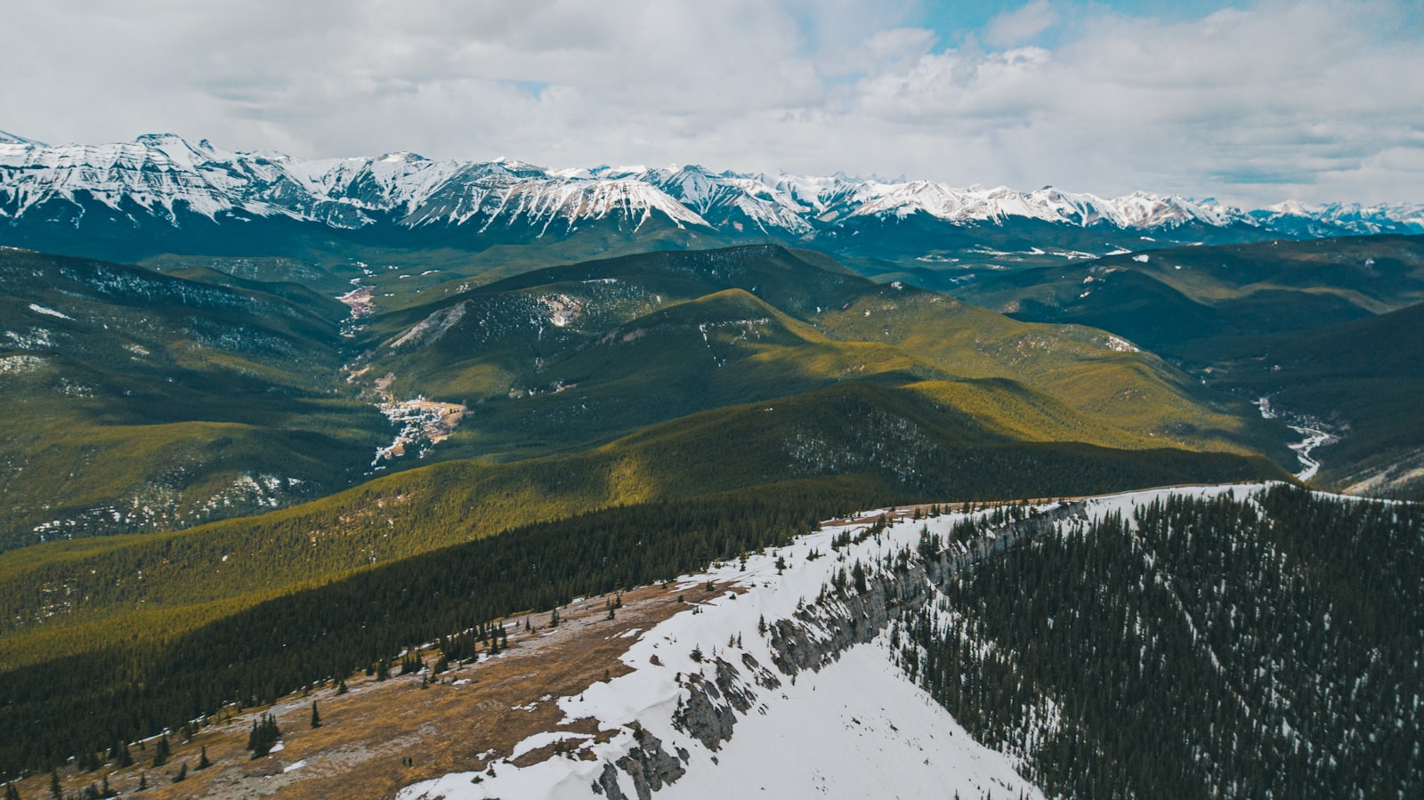 green grass field and snow covered mountain during daytime