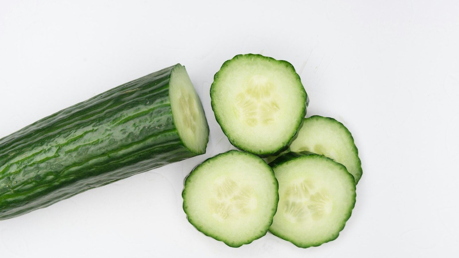 sliced cucumber on white surface
