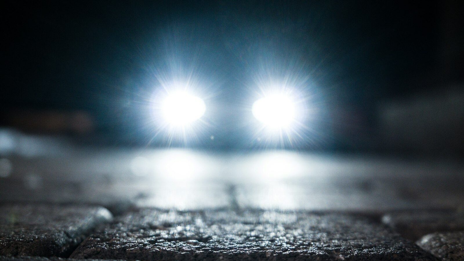 turned-on vehicle headlight on the street