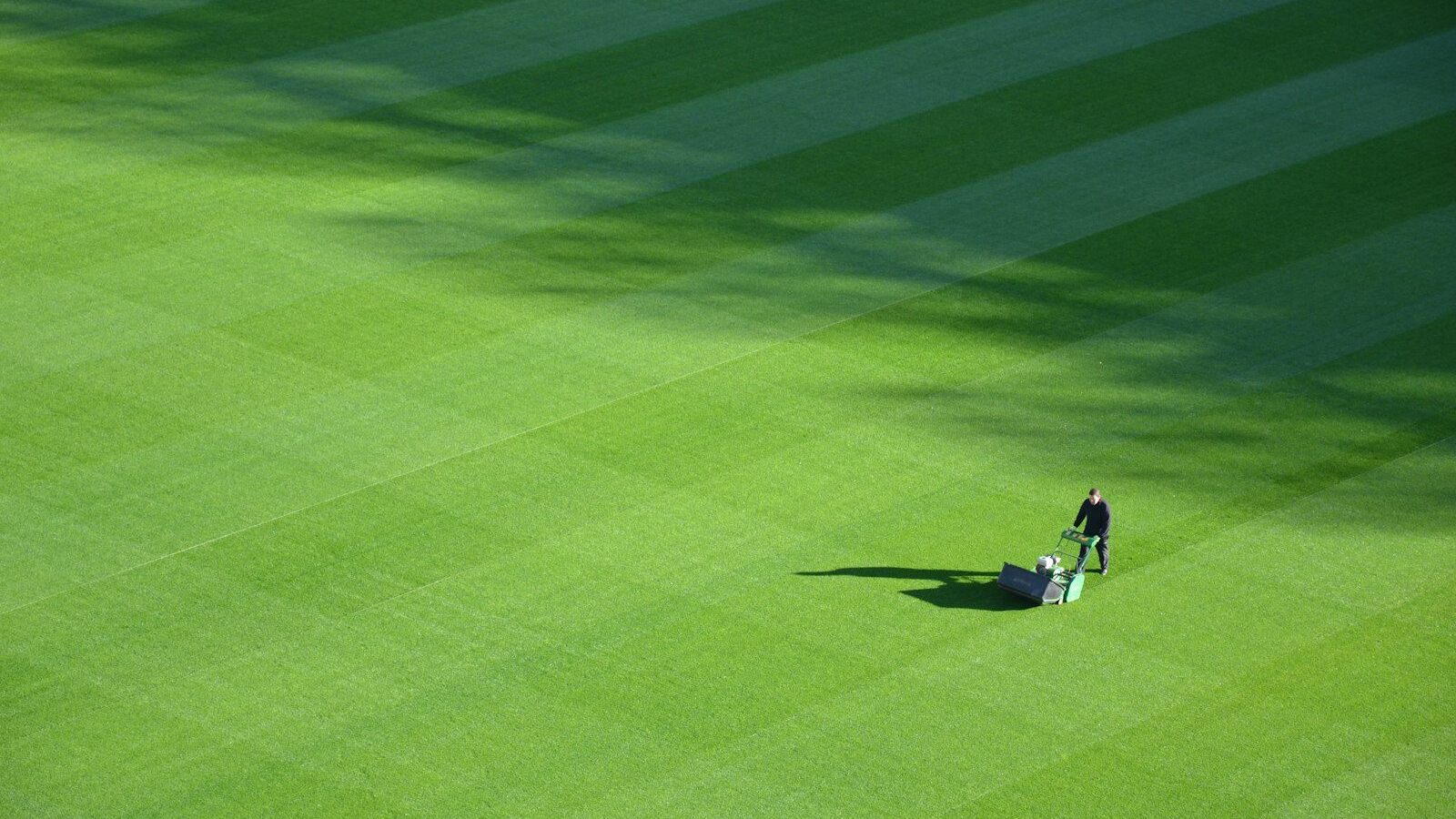 aerial photography of person trimming sports field during day