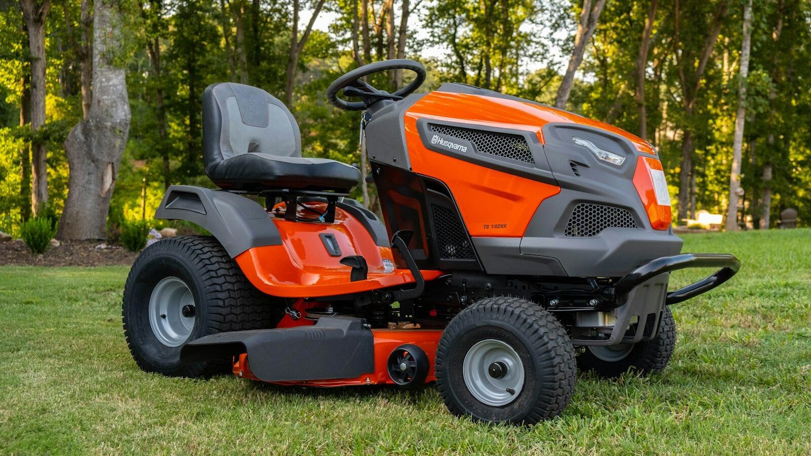 orange and black ride on lawn mower on green grass field