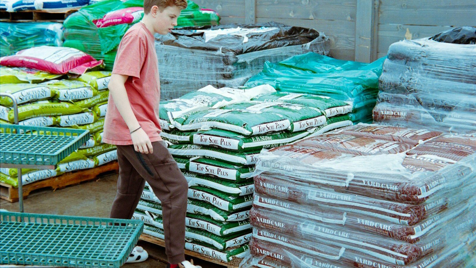 Young boy walks past stacks of bagged goods