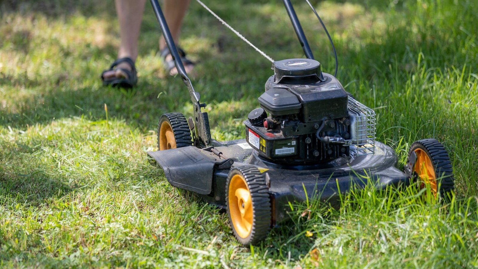 a person mowing the grass with a lawn mower